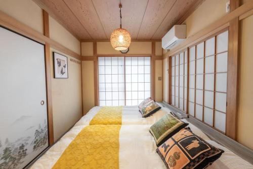 a bedroom with a large bed and windows at 暖迎の宿 in Tokyo