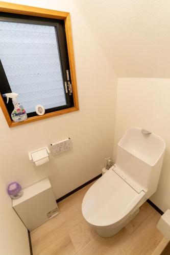 a bathroom with a white toilet and a window at 暖迎の宿 in Tokyo