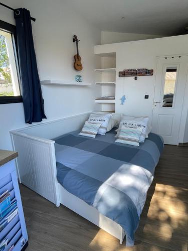 a bedroom with a bed with blue sheets and a guitar at Carro Zen in Martigues