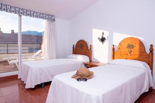 a hotel room with two beds with a hat on them at RVHotels Mar de Tossa in Tossa de Mar