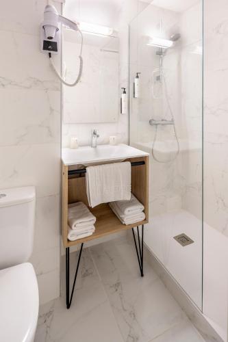 a bathroom with a sink and a shower at Hôtel Estival Arriel entièrement climatisé in Lourdes