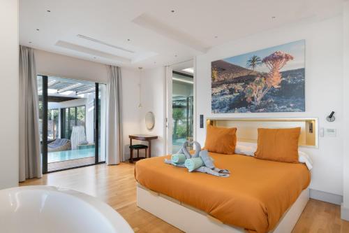 a bedroom with a large orange bed and a tub at Villa Liquen in Yaiza
