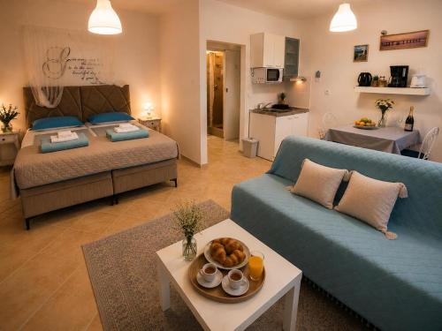 a living room with a blue couch and a bed at AMD Infinity Suites in Split