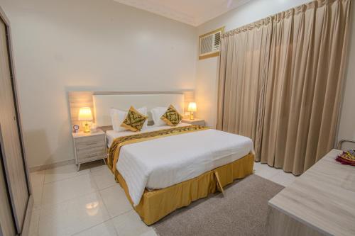 a hotel room with a bed and two lamps at صدي للشقق المخدومة in Khamis Mushayt