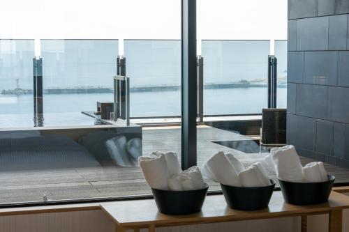 a group of containers on a table with a view of the water at Pearl Star Hotel ATAMI in Atami