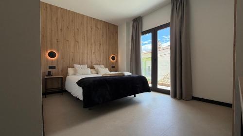 a bedroom with a bed and a large window at HS Olivos in Alcalá del Júcar