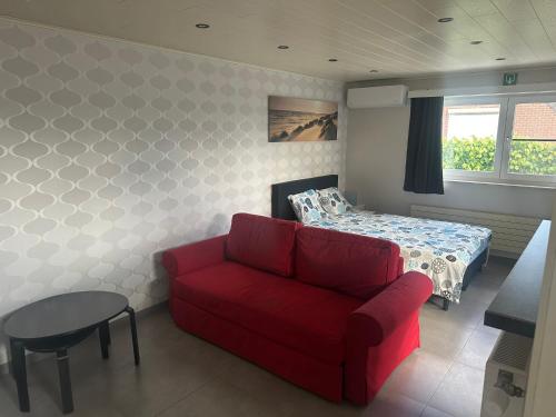 a living room with a couch and a bed at de Zeester in Bredene-aan-Zee