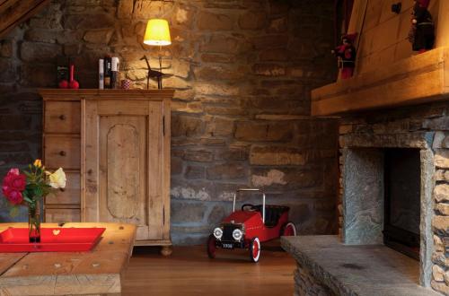 a room with a red toy car in a stone wall at Le Chalet de Lara in Val dʼIlliez