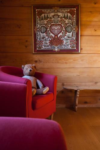 a teddy bear sitting in a chair in a room at Le Chalet de Lara in Val dʼIlliez
