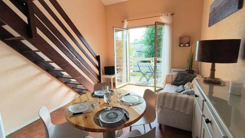 a living room with a table and a couch at Appartement du Port Neuf in Lanton