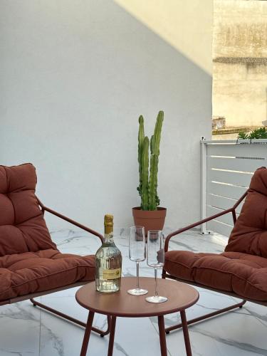 Eine Flasche Wein auf einem Tisch mit zwei Gläsern in der Unterkunft Kari Suite in Sammichele di Bari