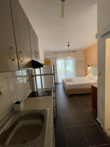 a kitchen with a sink and a bed in a room at Lofos Vourvourou in Vourvourou