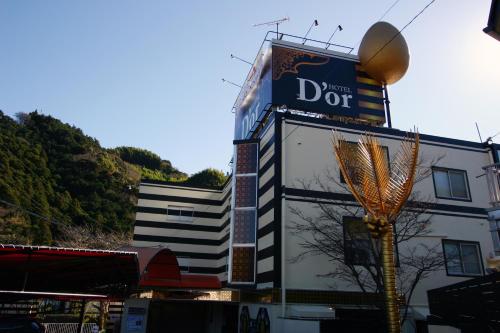 ein Gebäude mit einem Türschild an der Seite in der Unterkunft D'or ドール - レジャーホテル in Mochimune