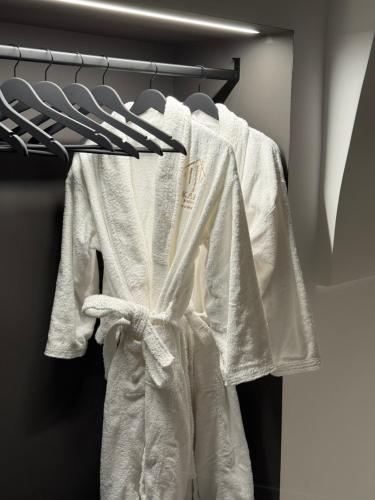 ein weißer Bademantel, der an einem Kleiderständer in einem Schrank hängt in der Unterkunft Kari Suite in Sammichele di Bari