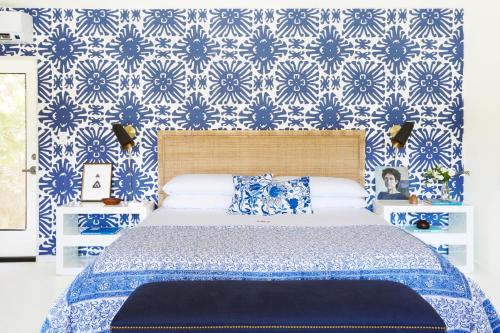 a bedroom with a bed with blue and white wallpaper at Holiday House Palm Springs in Palm Springs
