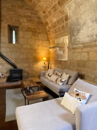 a living room with a couch and a stone wall at Ermita de la Tuda-Villaescusa de las Torres in Villaescusa de las Torres