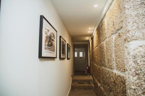 a hallway with three framed pictures on a wall at Casa de Couros in Guimarães
