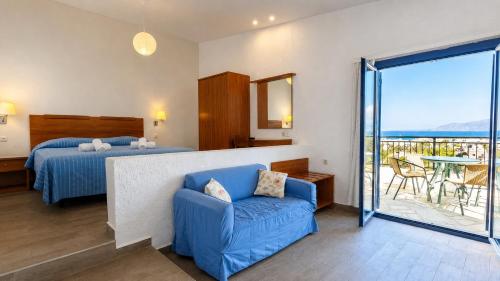 a bedroom with a bed and a couch and a balcony at Palatia Village Hotel Apartments in Hersonissos