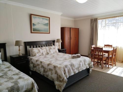 a bedroom with a bed and a table and chairs at Petronella Guest House in Bethlehem