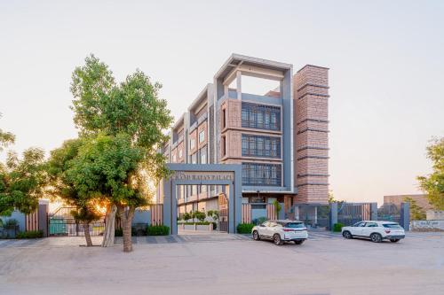 two cars parked in a parking lot in front of a building at Hotel Chand Ratan Palace By Travinities in Bikaner