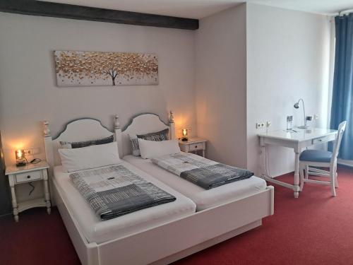 a bedroom with two beds and a desk and a sink at Hotel Hirsch in Sinsheim