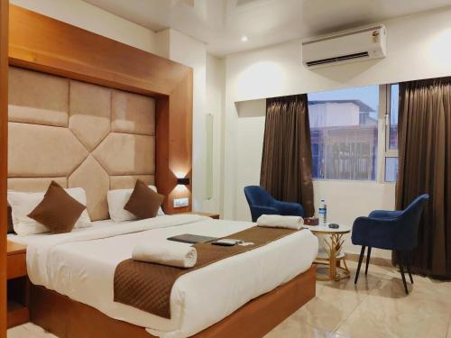 a hotel room with a bed and a table and chairs at Hotel Sterling Executive in Navi Mumbai