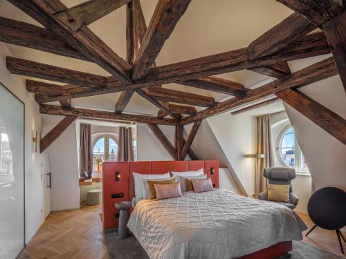 a bedroom with a red bed and wooden ceilings at The Botanist by Adrez in Prague