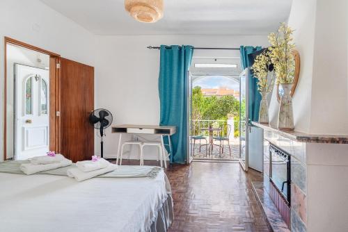 a hotel room with two beds and a balcony at Vivenda Aromas do Algarve in Monte Raposo