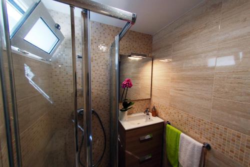 a bathroom with a shower and a sink and a mirror at Estrela do Mar - Alojamento Local in Calheta