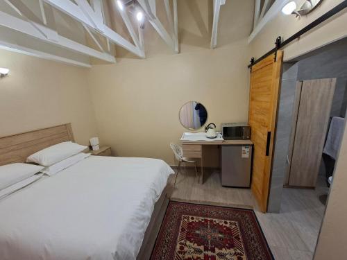 a bedroom with a bed and a desk with a mirror at De Windmolen in Centurion