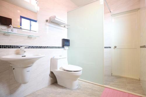 La salle de bains est pourvue de toilettes, d'un lavabo et d'une douche. dans l'établissement Marathon B&B, à Taïtung