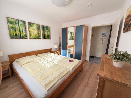 a bedroom with a bed and a table and windows at Ferienwohnung Kleine Müritz in Rechlin