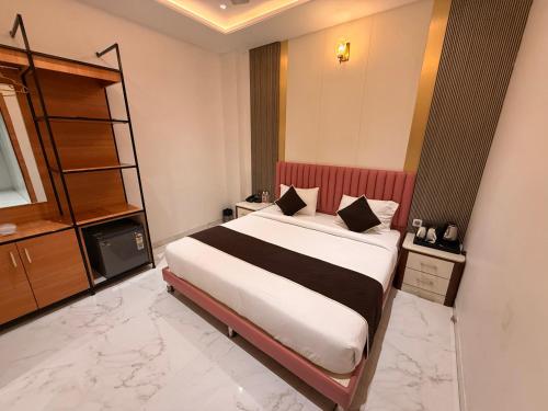 a bedroom with a large bed in a room at Hotel Rosewood in Prayagraj