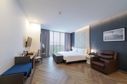 a hotel room with a bed and a chair at Aston Kemayoran City Hotel in Jakarta