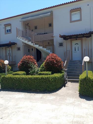 a building with a staircase and bushes in front of it at Analipsis Messinis Apartments in Análipsis