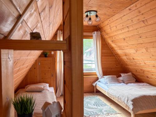 a bedroom with two beds in a wooden house at Willa Wielka Puszcza in Porąbka