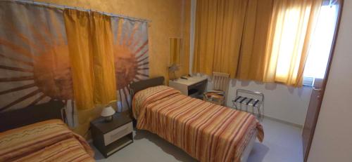 a hotel room with two beds and a mirror at Eurelios in Adrano