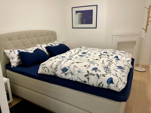 a bed with a blue and white comforter on it at Appartement Zirbe in Rickenbach