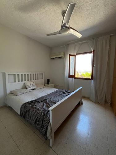 a bedroom with a bed and a ceiling fan at The Citrus Valley in Pissouri