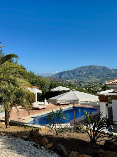 a resort with a swimming pool and mountains in the background at Vida Lenta Boutique Finca in Alora