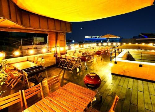 an outdoor patio with tables and chairs and lights at Daecheon Mud Gongju Pension in Boryeong
