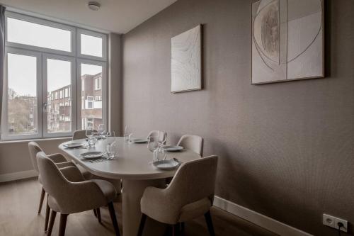 a dining room with a table and chairs and a window at Spacious family home in Schiedam