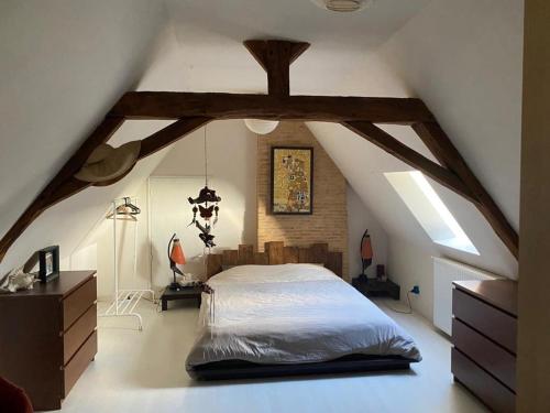 a bedroom with a large bed in an attic at Maison Périgourdine familiale in Saint-Jean-dʼEyraud