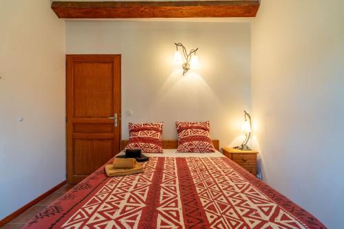 a bedroom with a large bed with red pillows at Les Acacias in Colombiers