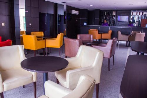a restaurant with tables and chairs and a bar at Emglo Suite in Lagos