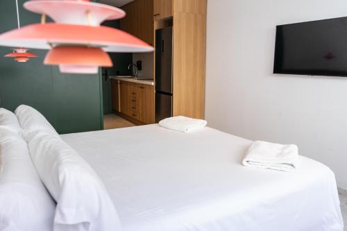 a bedroom with a white bed and a flat screen tv at The Boc Hostels - City in Palma de Mallorca