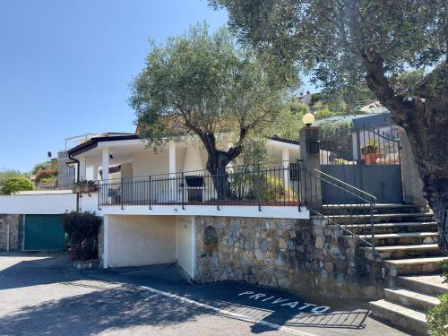 a white house with stairs and a tree at Villa Thalea in Diano Marina