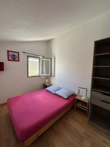 a bedroom with a large pink bed in a room at Maison petit havre de paix in Palavas-les-Flots