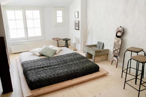 a bedroom with a bed and stools in it at Flusshaus BnB Okavango in Brugg
