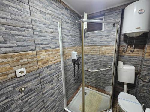 a bathroom with a glass shower with a toilet at Prenociste Simke 2 in Subotica
